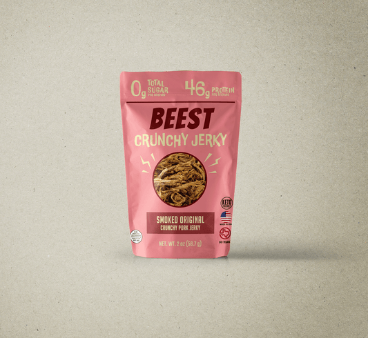 Front of pink BEEST Crunchy Jerky OG Pork bag showing 0 g sugar and 46 g protein