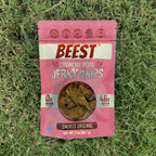 A 2 oz bag of BEEST Pork Jerky Chips, Smoked Original, lying on green grass